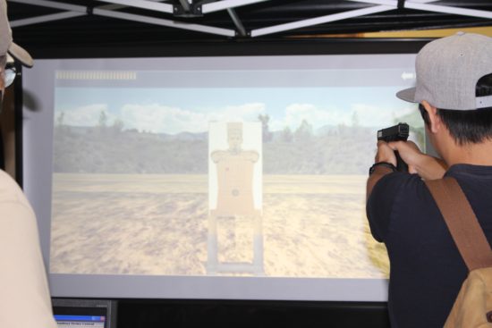 Peninsula student Jordan Yakumo Tan participating in the Clallam County Sheriff’s Office shootout simulator. - Photo by Mike Drake