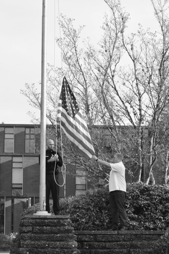 The two raise the replacement flag after perform- ing the retirement ceremony.  - Photo by Mike Drake