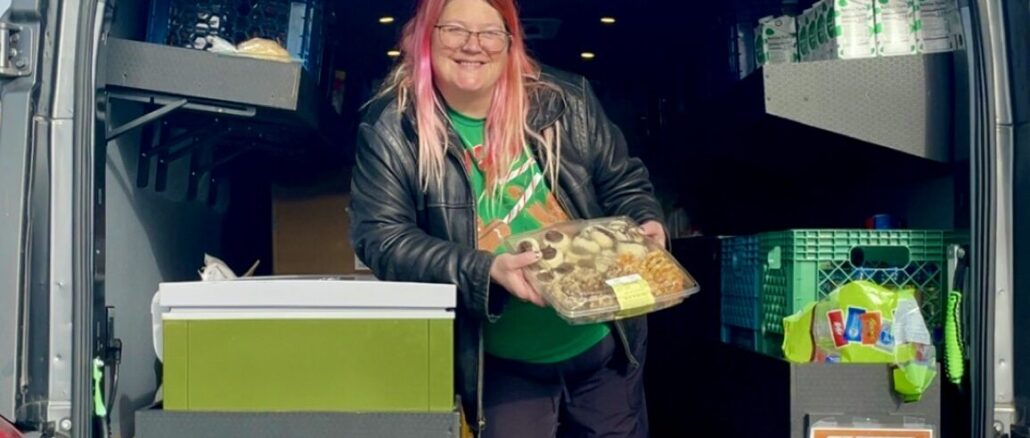 A Port Angeles Food Bank employee handing food out to Peninsula College students