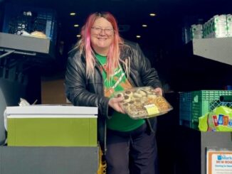 A Port Angeles Food Bank employee handing food out to Peninsula College students